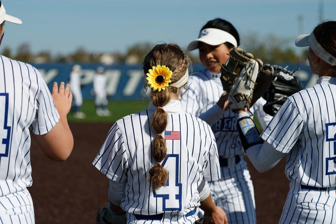 Apr 22, 2024; Powell, Ohio, USA; Olentangy Liberty's Izzy Matteo (4) with a sunflower in her hair before the high school softball game against Hilliard Bradley at Olentangy Liberty High School. Hilliard Bradley won 3-2. Mandatory Credit: Graham Stokes-The Columbus Dispatch