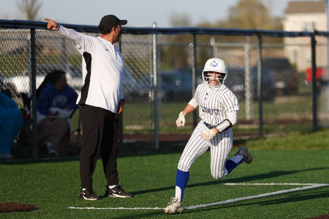 Apr 22, 2024; Powell, Ohio, USA; Olentangy Liberty's Izzy Matteo (4) rounds third in front of Olentangy Liberty head coach Ty Kashmiry during the high school softball game against Hilliard Bradley at Olentangy Liberty High School. Hilliard Bradley won 3-2. Mandatory Credit: Graham Stokes-The Columbus Dispatch