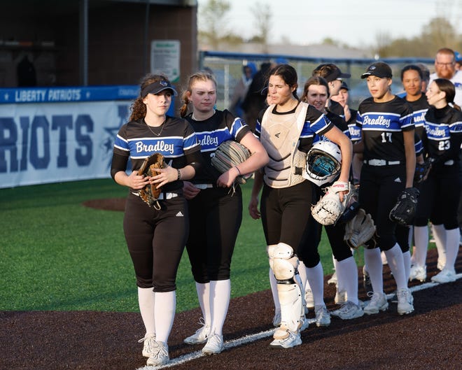 Apr 22, 2024; Powell, Ohio, USA; Hilliard Bradley's Cora Moine (4), pitcher Mickey Moody (32) and catcher Loghan Cromer (11) lead the team at the end of the high school softball game at Olentangy Liberty High School. Hilliard Bradley won 3-2. Mandatory Credit: Graham Stokes-The Columbus Dispatch