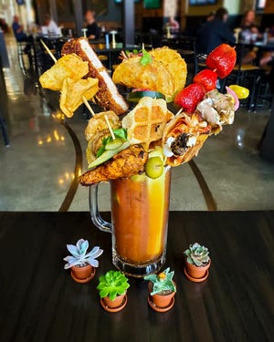 A whole bouquet of garnishes, from a hot wing to sugar-coated strawberries, accompanies 22 ounces of cocktail in the Market Mary, It's a collaboration of the market's Railhouse bar and 10 vendors.
